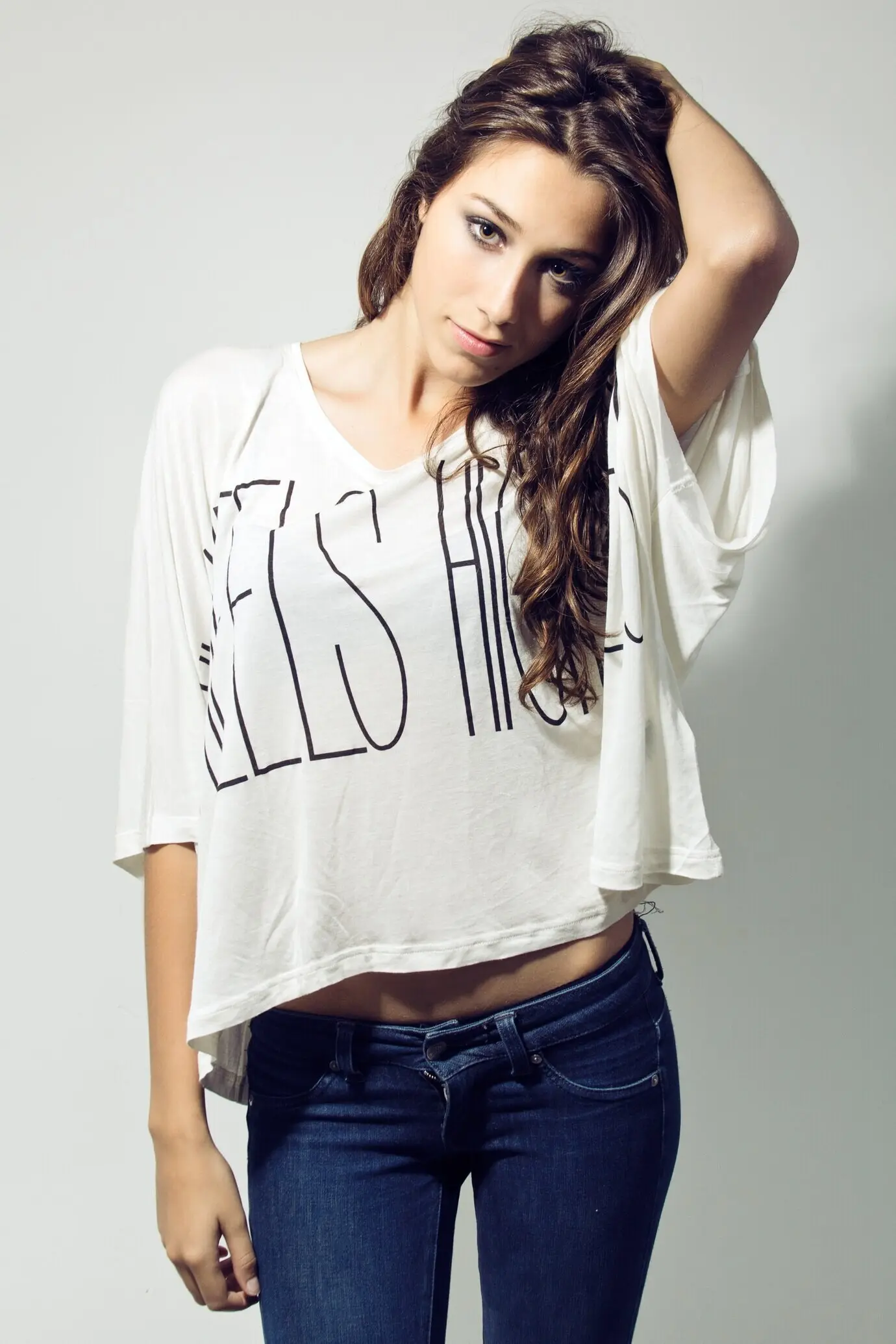 Studio-Porträt einer schönen jungen Frau, die in die Kamera blickt.