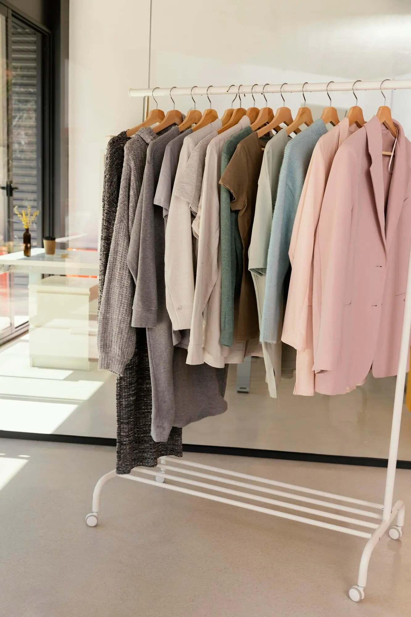 Bekleidungsgeschäft mit einem Kleiderständer, an dem Kleidung hängt.